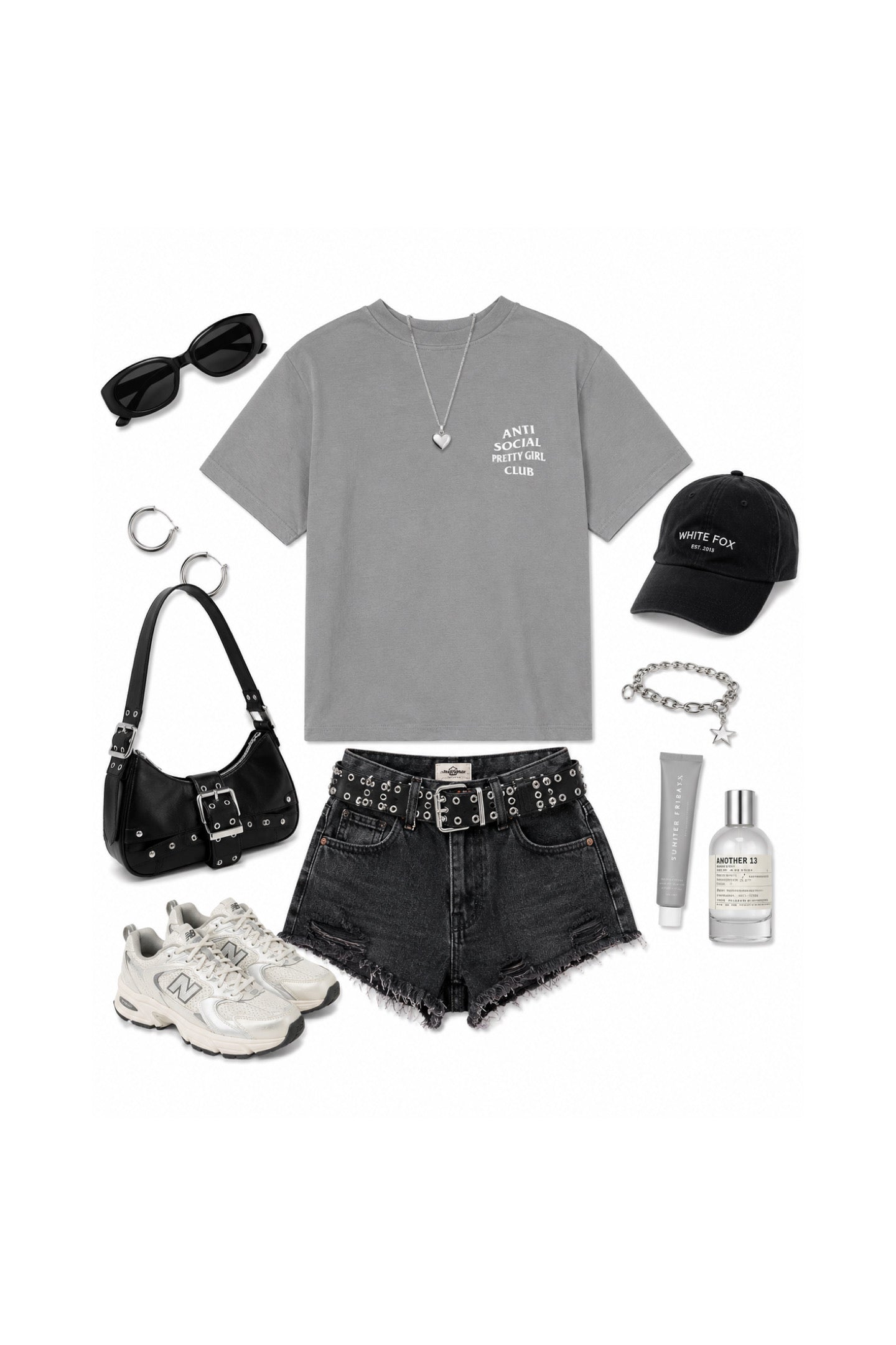 A styled flat lay outfit on a white background featuring a gray graphic t-shirt, black denim shorts, a black studded belt, white sneakers, a black shoulder bag, black sunglasses, a black baseball cap, a silver necklace, a silver bracelet, and a silver tube of lip balm.