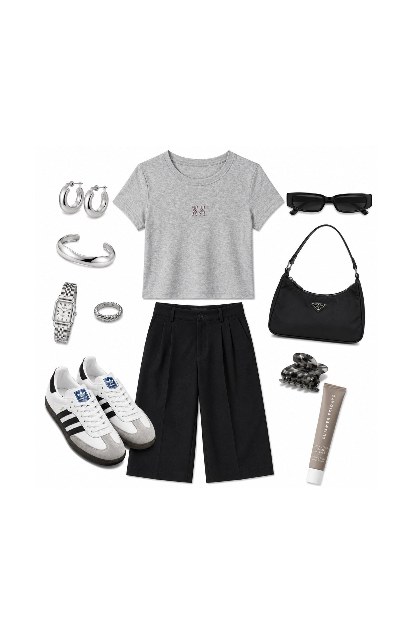 A flat lay outfit arrangement on a white background featuring a light gray short-sleeve crop top with a small pink embroidered logo, black wide-leg shorts, black sunglasses, a black Prada shoulder bag, white and black Adidas sneakers, silver hoop earrings, a silver cuff bracelet, a silver watch, a silver ring, a black beaded bracelet, and a beige tube of lip balm.